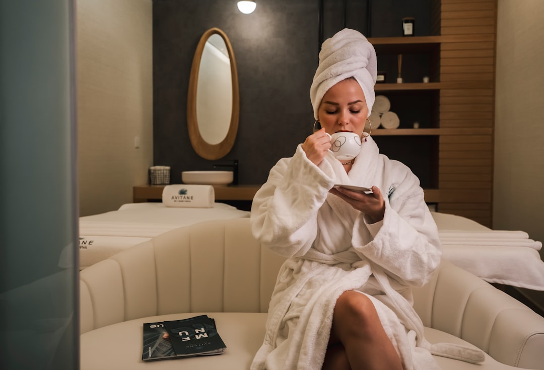 woman in white robe sitting on white couch - Photo by Usen Parmanov on Unsplash